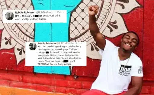 A young man poses in front of a mural, raising his closed fist and smiling.