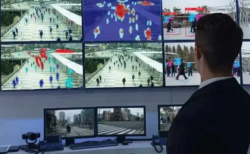 shutterstock image: A security professional monitors several screens showing individuals detected by facial recognition software.
