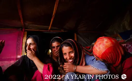 a group of young women sit in a group and laugh together