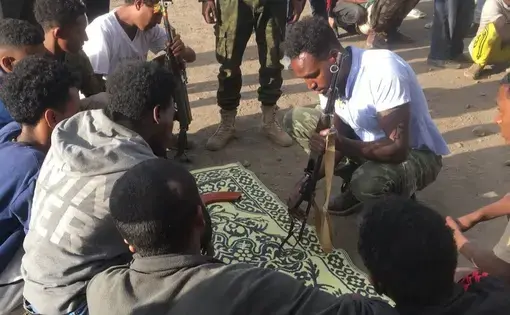 soldiers crouch over a prayer rug in Ethiopia