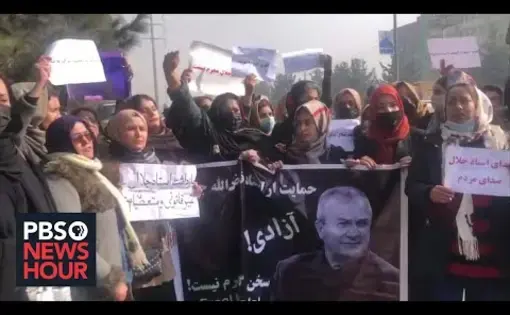 Women hold up protest signs