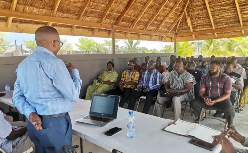 A person presents in front of an outdoor audience.