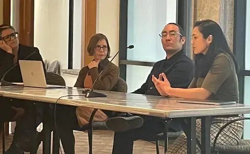 Four people sit at a folding table