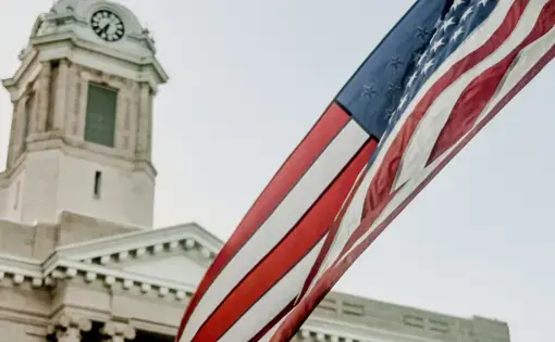 A closeup of an American flag outside of a courthouse