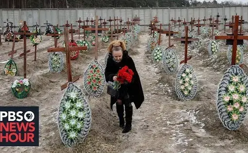A woman walks through a graveyard, Ukraine