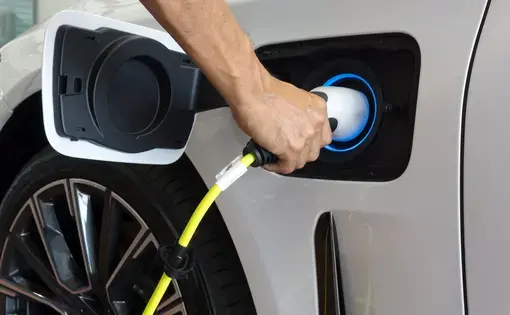A person plugging in an electric car