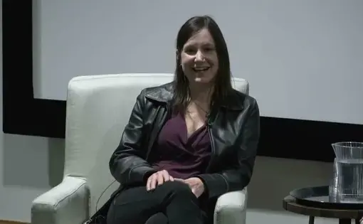Jackie Spinner smiles in an arm chair