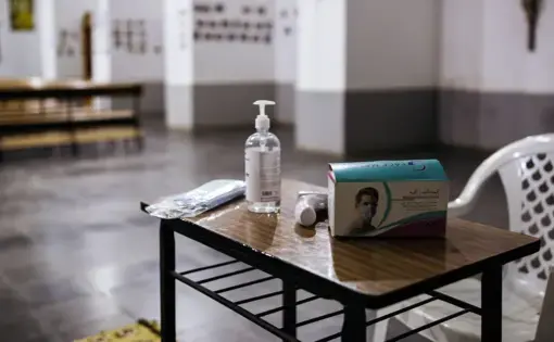A table with masks, hand sanitizer, and a thermometer