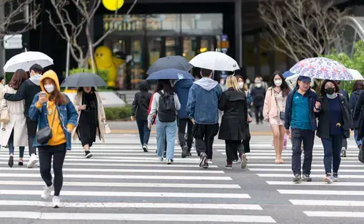 People walk across a city crosswalk