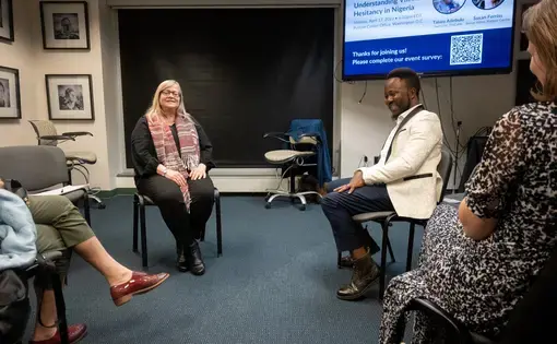 Susan Ferriss, left, and Taiwo Adebulu, right, laugh as they compare pandemic responses between their countries.