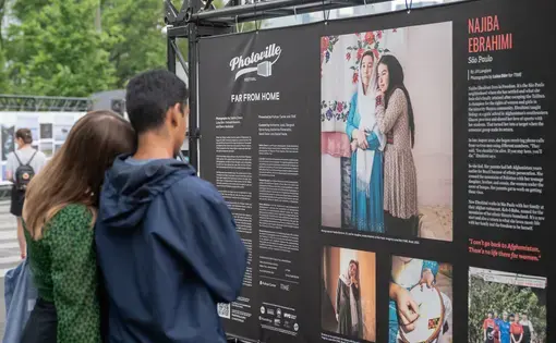 A couple looks at a Photoville exhibit