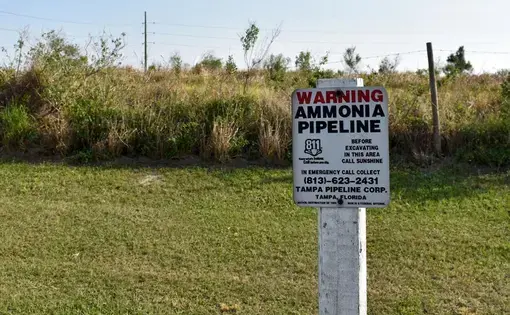 A warning sign in an empty field warns of an ammonia pipeline in Tampa, Florida.