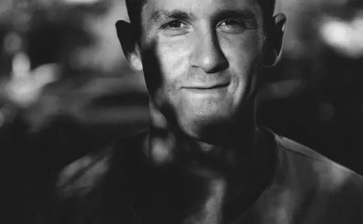 Black and white photo of a man under a tree