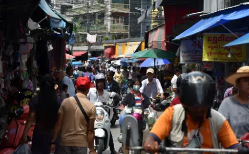 Motorists and pedestrians crowd a small street