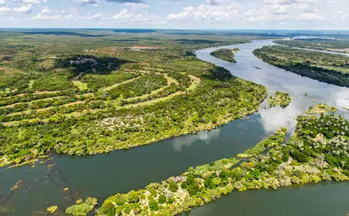 Overhead image of a river with lush trees along its bank