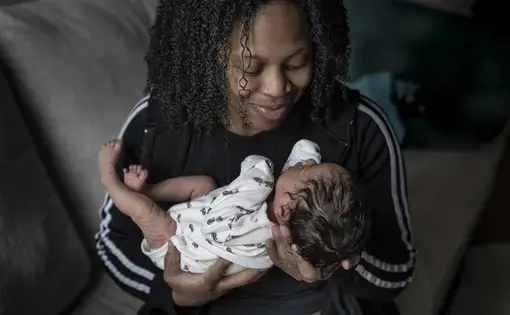 a mother holds her newborn baby