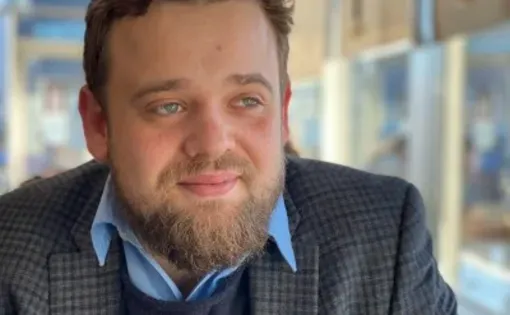 photo of a man with short hair and a beard in a blazer