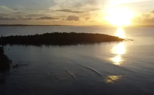 Sun sets over a body of water