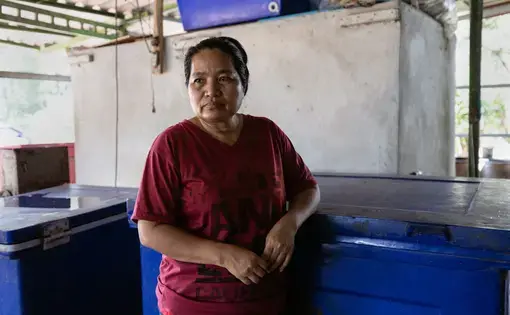 A woman stands in a kitchen.