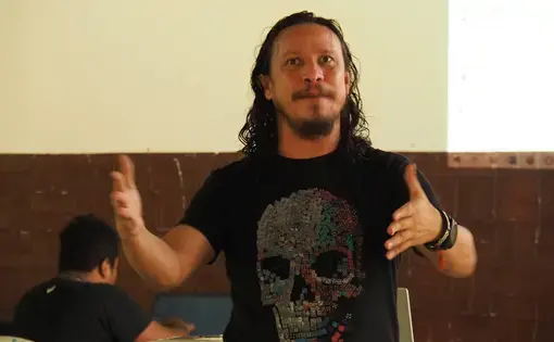A man in black t-shirt giving a speech.