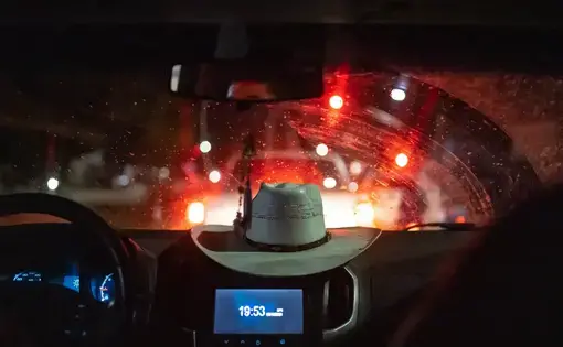 A hat against red car tail lights.