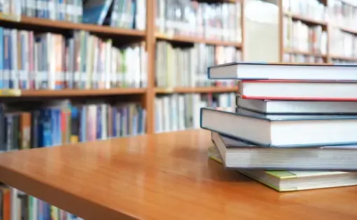 A stack of books on a wood table