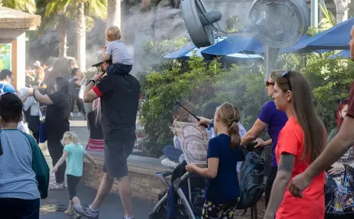 Universal City, CA, USA - Mar 21, 2022: Visitors walk past outdoor misting fans at Universal Studios Hollywood theme park. Southern California is seeing big weather warm-up with spring heat wave.