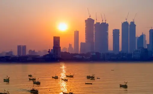 Hazy skyline over the water at sunset - Mumbai, India. Image by muratart/Shutterstock.