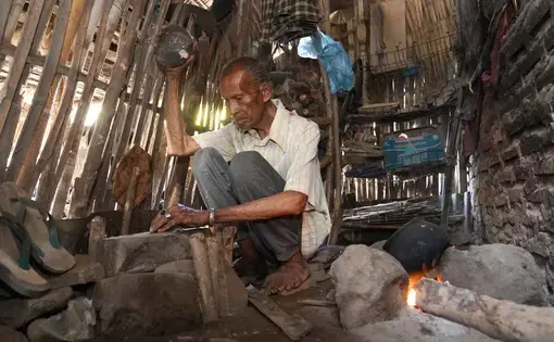 A man pounding and roasting a jackbean.