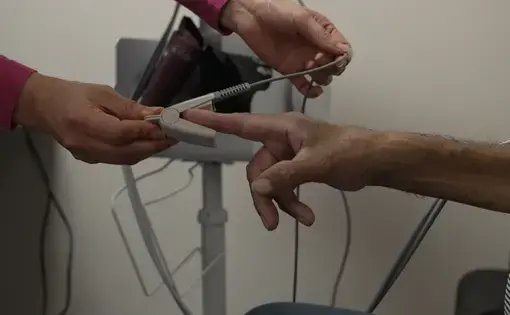 a nurse places a medical device on a patient's finger