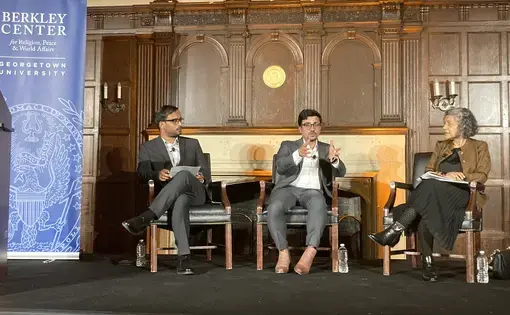 Three people sitting on stage at Georgetown