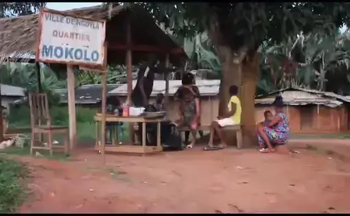 A group of women sit around their house.