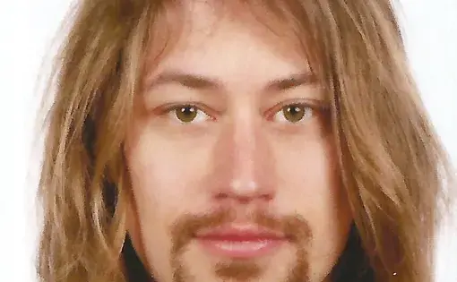 A man with long light-colored hair and facial hair