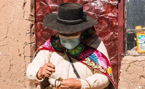 Indigenous woman in Peru wearing mask for COVID-19. Image by Lroy/Shutterstock.