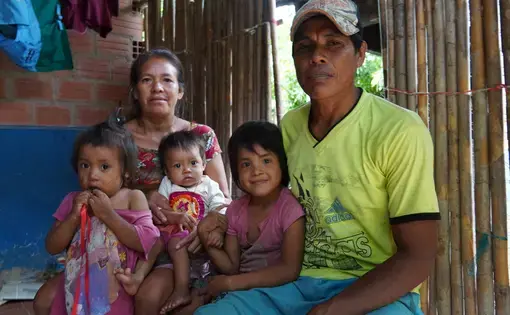 A family of five looks happily into the camera.