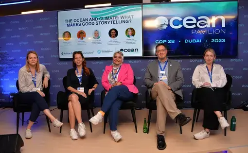 Jessica Aldred, Aryn Baker, Eman Mounir, Ken Kostel, and Natalie Hart sit on a small stage with a blue backdrop that reads Ocean Pavilion, CEAN, COP 23, Dubai 2023.