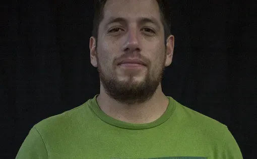 Headshot of a man wearing a green shirt