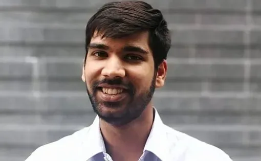 Headshot of a man with short dark hair wearing a white button-down