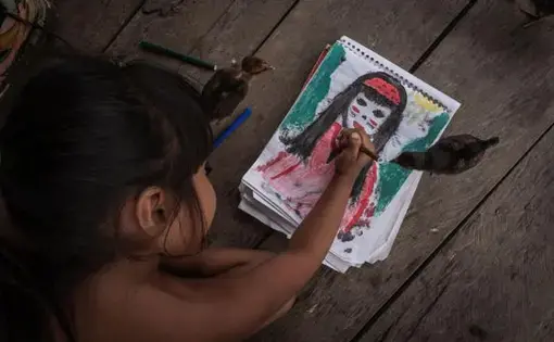 A little girl draws a picture.