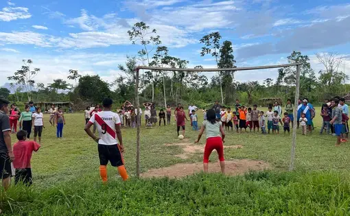 Against the backdrop of a beautiful sunny day, people play football.