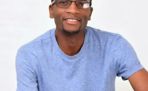 A man with glasses wearing a blue t-shirt