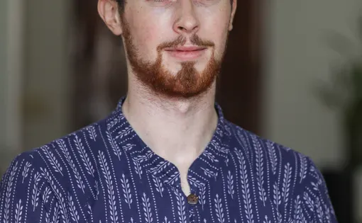 A close-up shot of Jack in a printed blue shirt.