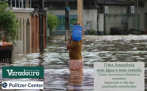A man is half submerged in overflowing water while he carries a blue can of clean water on his shoulders.