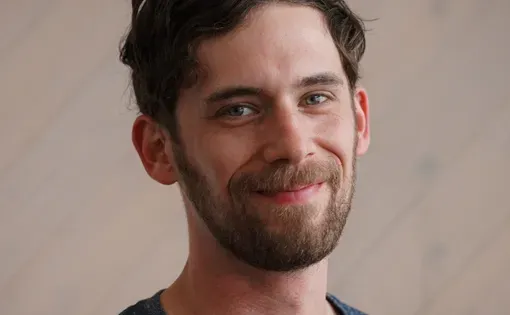 Headshot of Matthew wearing a blue shirt