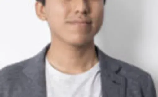 Headshot of Gianfranco wearing a grey blazer and white tshirt