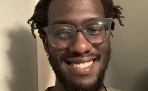 headshot of Carey wearing glasses and a green t-shirt