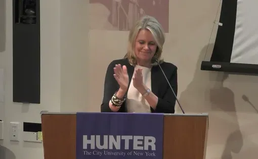a speaker claps at a podium with "Hunter" logo on it