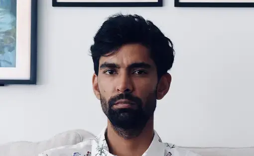 Headshot of Atul wearing a white printed button-down