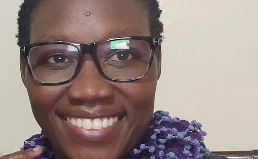 Image of Moraa wearing glasses and a purple scarf