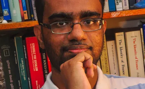 Headshot of Uditha wearing a striped shirt